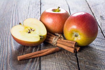 Apples with cinnamon on wooden surface