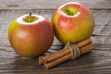 Apples with cinnamon on wooden surface