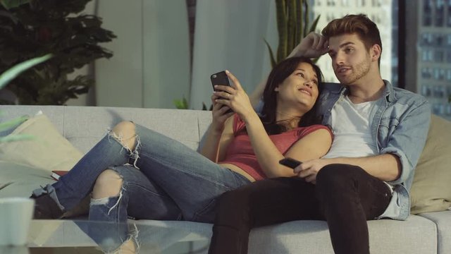  Affectionate couple relaxing at home & taking selfie with smartphone