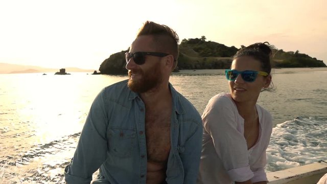 Happy couple floating on the sea during sunset, slow motion shot at 240fps, steadycam shot 
