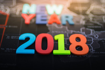 Wooden colourful number '2018' place on black map , using as new year concept