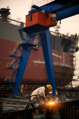 A welder at a shipyard