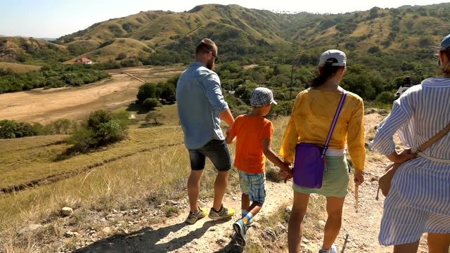People walking the path on the hill, slow motion shot at 240fps, steadycam shot 
