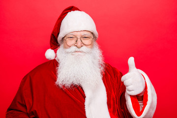 Who like to have presents and holly jolly x mas? Festive seosonal occasion. Funny Saint Nicholas in red traditional outfit, isolated on red background, shows agree good gesture, wishing happiness