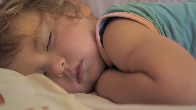 Newborn cute baby sleeping. Close Up portrait, caucasian child. Adorable little boy sleeping in a bed.