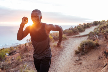 Fit young man running alone along an oceanside trail
