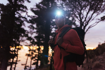 Young African man hiking alone in the woods at dusk © mavoimages