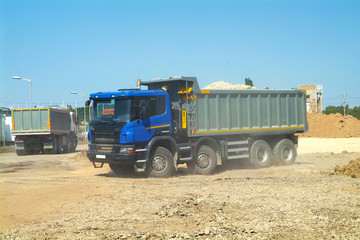 Fully loaded modern dump trucks preparing to on construction site