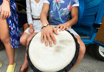 close up of hippie friends playing tom-tom drum