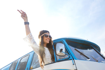 happy hippie woman showing peace in minivan car