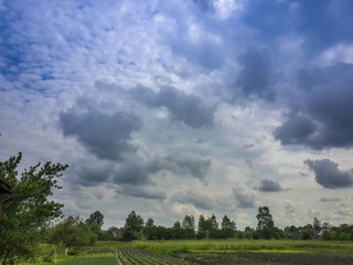 Beautiful thunderstorm clouds in dusky sky and countryside landscape