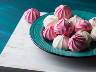 Pastel color pink and white meringue on green background