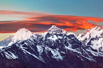 Photo sur Plexiglas Manaslu Chaîne de montagnes enneigée avec des nuages lenticulaires orange vif au coucher du soleil