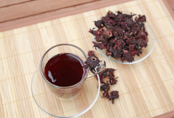 Roselle juice with dried roselle on wooden mat.