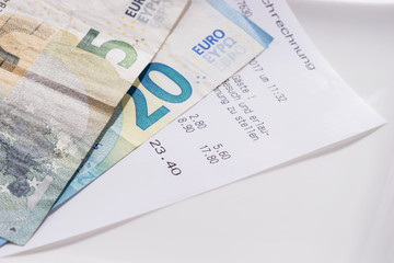 Rechnung und Bargeld auf dem Teller, Trinkgeld inklusive