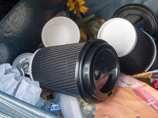 black coffee cup inside bin outside in public
