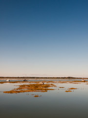 peaceful blue space river estuary scene outside bright sunny day boats moored