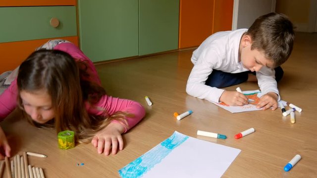 View of children drawn in paper, lying on the floor at home.