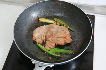 Pork meat steak fried in a pan.