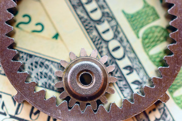 metal gears on dollar banknotes