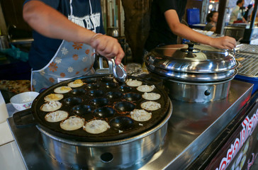Local seller make Thai sweet grilled coconut-rice hot cake, Kanom krok at floating market, Bangkok, Thailand