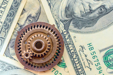 metal gears on dollar banknotes