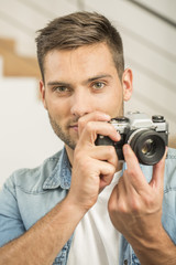 Man at home using vintage reflex camera
