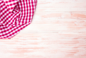 The checkered tablecloth on wooden table.