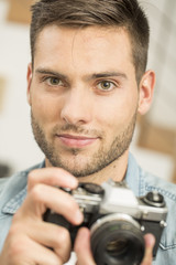 Man at home using vintage reflex camera