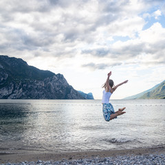 Woman jumping at the lake