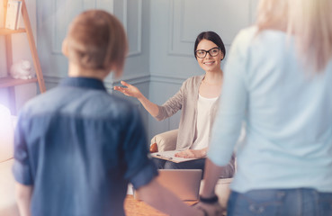 Obraz premium Positive school psychologist welcoming teen boy and his mother