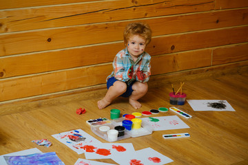 Boy painter painting on wooden floor