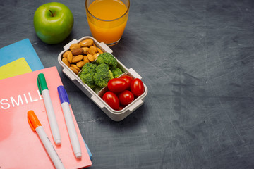 School breakfast on desk with books and pen on board background