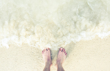 Foot/feet on beach/sea water, relaxing on vacation, holiday, freedom, lifestyle.