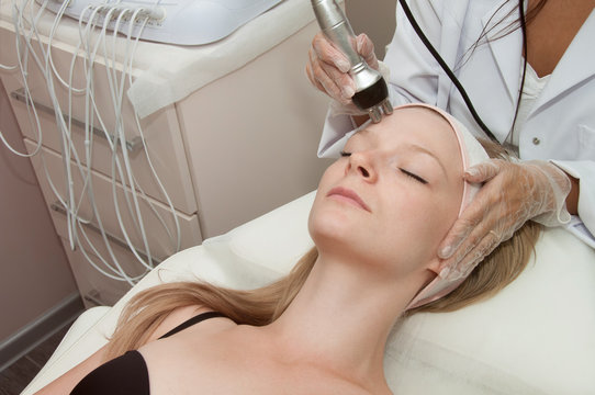 Hardware cosmetology. Young blonde woman getting rf lifting procedure in a beauty salon.