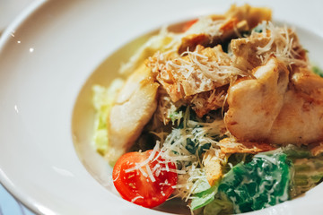 Chicken Caesar Salad. Caesar Salad with grilled chicken on plate. Grilled chicken breasts and fresh salad in plate