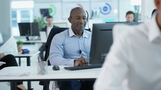  Friendly customer service operator talking to customer in busy call centre