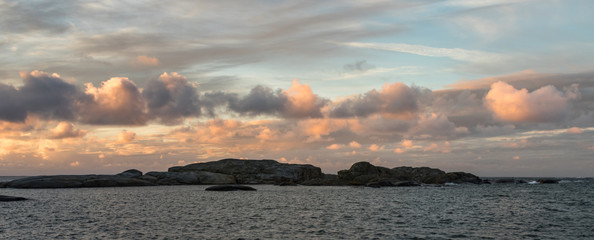 Obraz premium Sunrise with pink sky and clouds over the ocean and archipelago of Faerder National Park, Norway, panorama