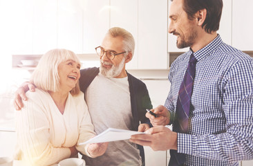 Joyful aged couple working with real estate agent