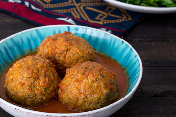 Close up of Koofteh Tabrizi Large Meatballs Stuffed With Dried Fruits, Berries And Nuts In Tomato Turmeric Broth A Traditional Azeri And Iranian Dish Served In Turquoise Bowl