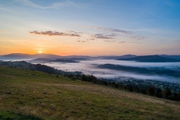 Obraz premium Beautiful foggy sunset in Polish mountains Silesian Beskid.