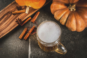 Frothy spicy pumpkin Ale or beer in glass mug, on black background, copy space