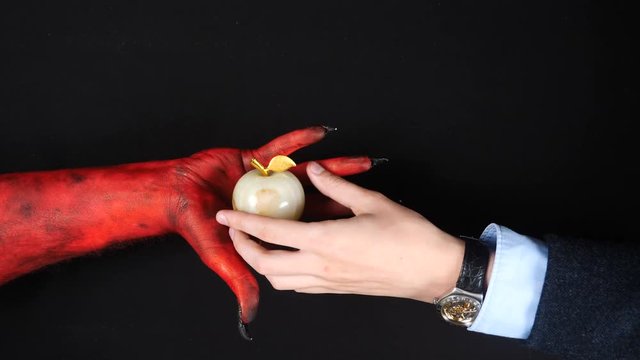 Devil gives a gold paradise apple to a man.
