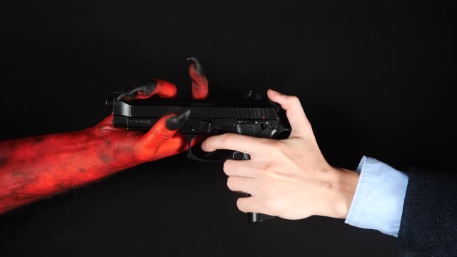 Devil gives a gun to a man.