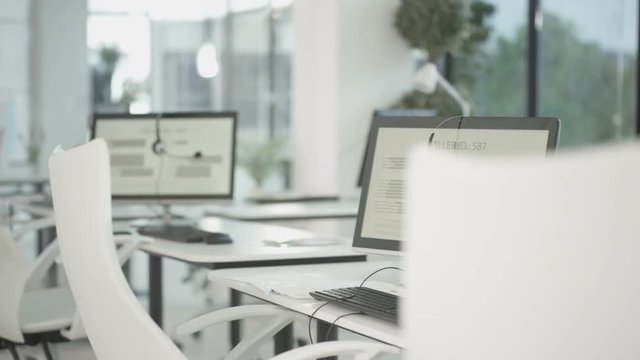  Workstations in a telesales office, headsets on computer monitors