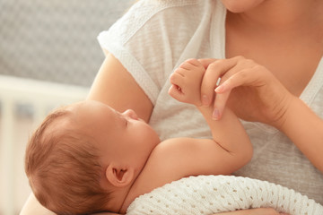 Mother holding sleeping newborn baby, closeup