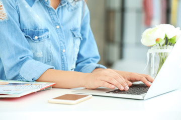 Female blogger with laptop and cell phone at table