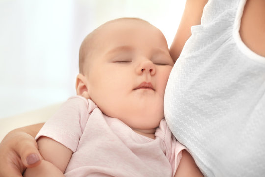 Mother holding sleeping baby, closeup