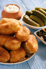 Fried pies on wooden table, russian style cuisine.