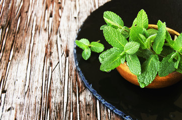 Fresh mint in a wooden bowl, selective focus